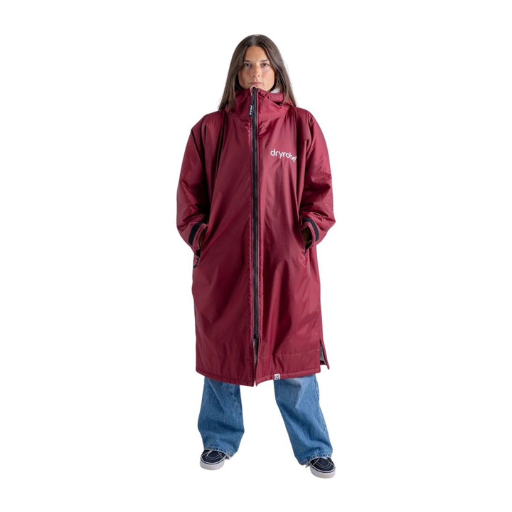 Person wearing a red raincoat with a brand logo on a white background