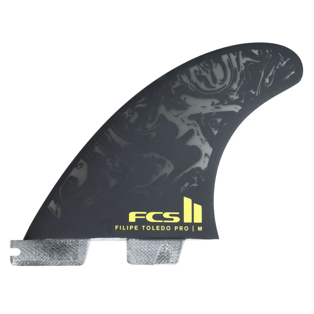 black surfboard fin with yellow FCS Filipe Toledo Logo