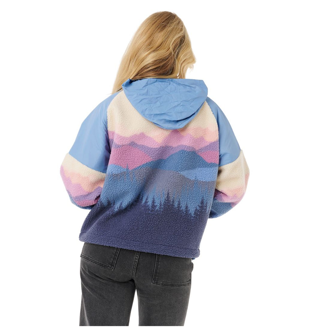 Person wearing a colorful mountain-patterned hoodie on a white background
