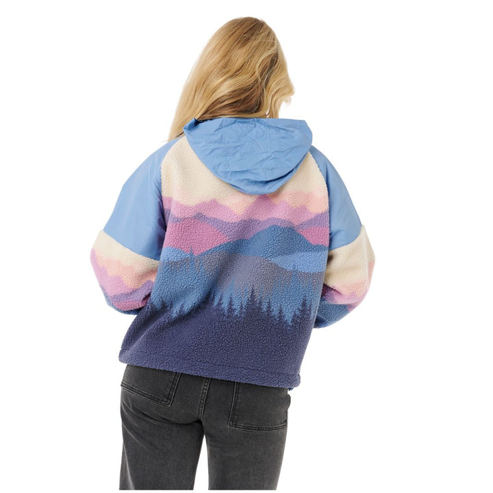 Person wearing a colorful mountain-patterned hoodie on a white background