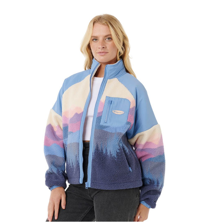 Woman wearing a colorful patterned jacket on a white background