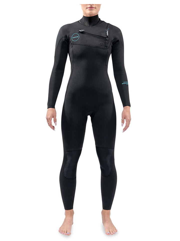 A woman is wearing a black Dakine Mission chest zip womens wetsuit with blue detailing.