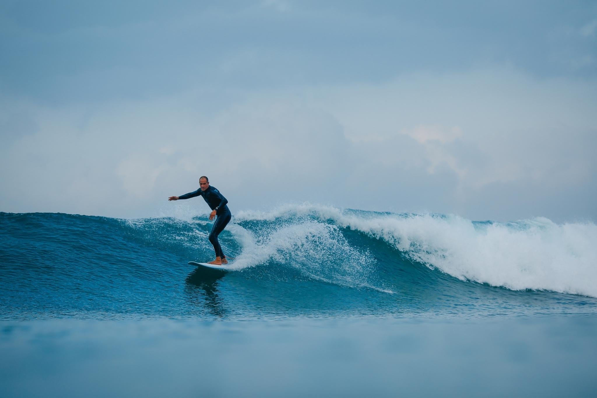 Man surfing a cruisy wave on an NSP Longboard