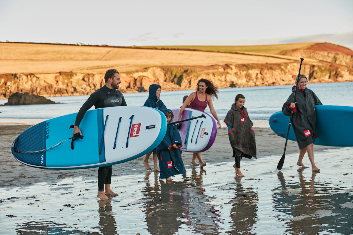 Family in Ireland going stand up paddle boarding at the beach. 