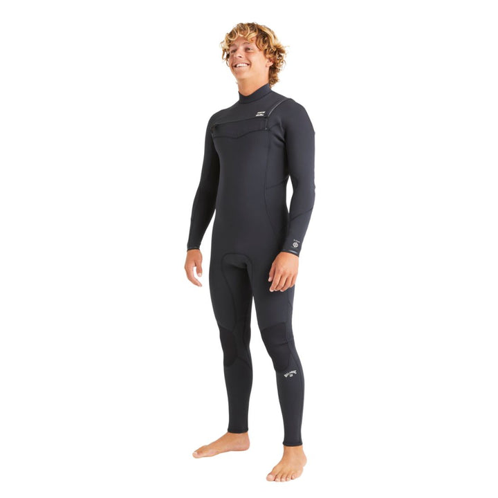 A man standing in a black long sleeve Billabong Absolute Natural 3/2mm mens wetsuit with a chest zip entry system.