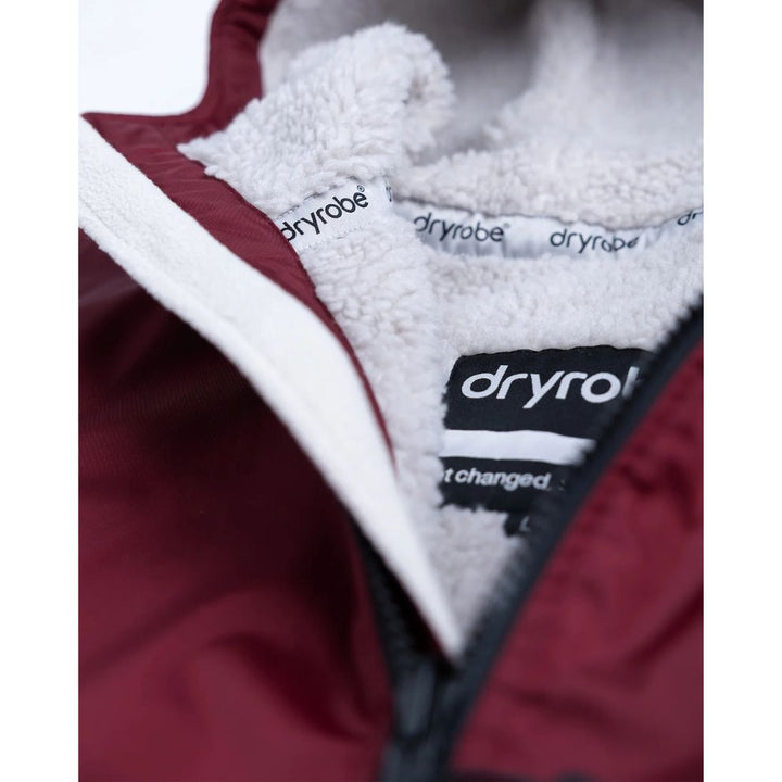 Close-up of a maroon garment with white sherpa lining and 'Dryrobe' branding.