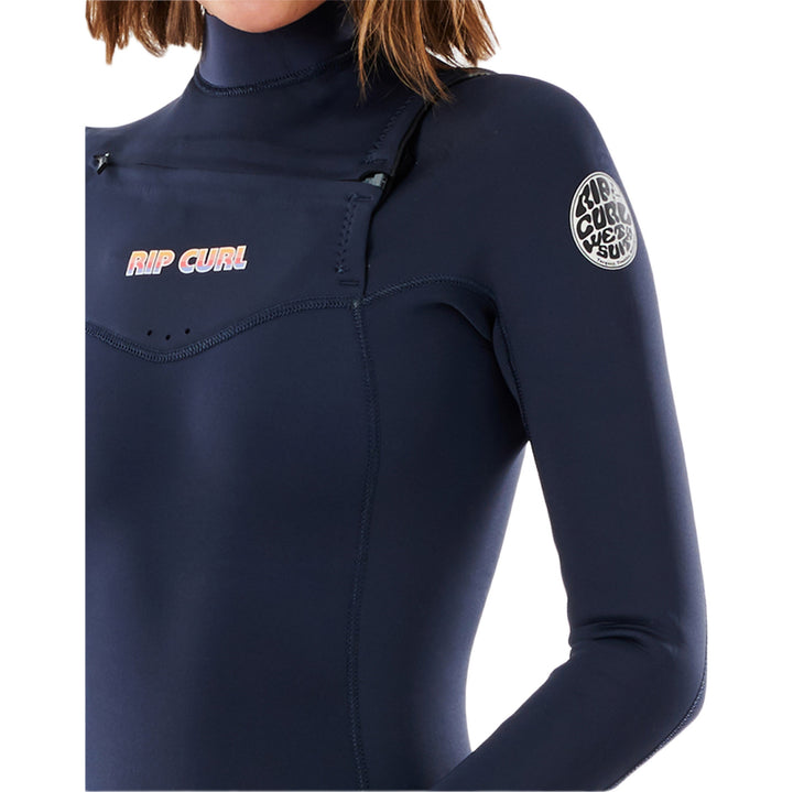 Close up of a woman wearing a navy blue chest zip Rip Curl Dawn Patrol Performance 5/4mm womens wetsuit with long sleeves and a high neck.